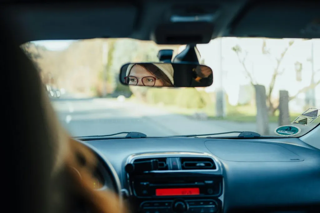 Blick vom Rücksitz auf eine Person am Steuer