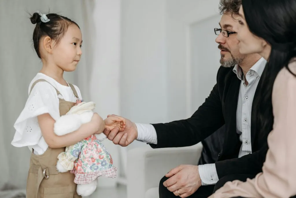 Ein Kind begrüßt einen Erwachsenen mit Handschlag